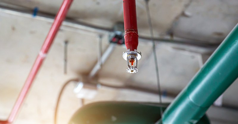 Are Barndominiums Safe: 7 Essential Safety Tips 4 A silver fire sprinkler head with a red bulb, ready to activate in case of fire
