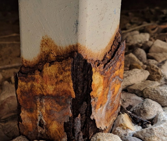 Are Barndominiums Safe: 7 Essential Safety Tips 7 A corroded metal support beam with exposed rust and deteriorating surface