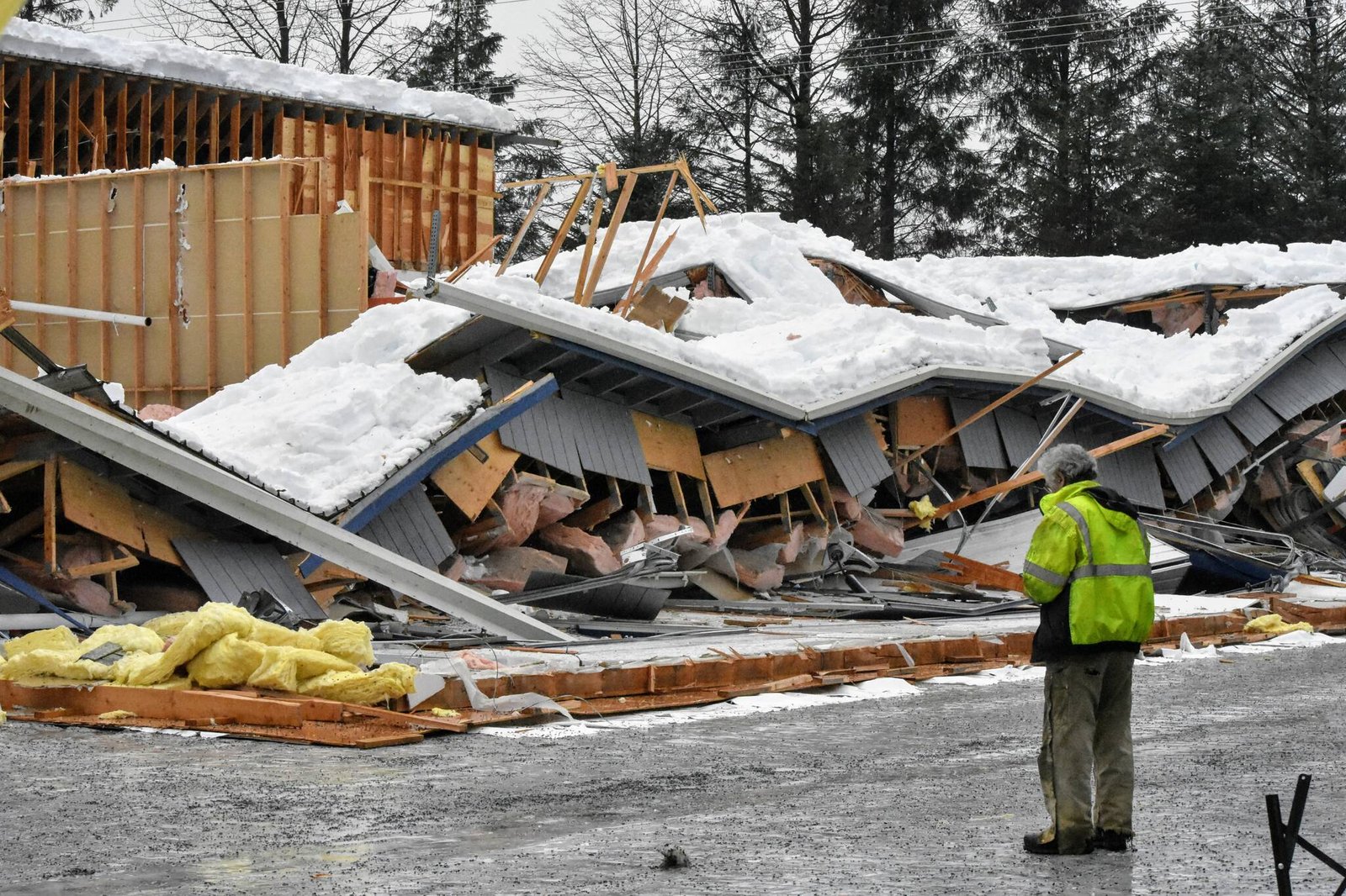 a man standing next to a collapsed building